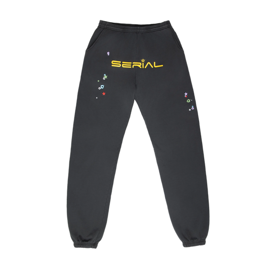 Front view of black sweatpants with yellow 'SERIAL' text and colorful star designs